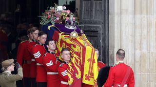 The coffin of Queen Elizabeth II with the Imperial State Crown resting on top is carried by the Bearer Party as it departs Westminster Abbey