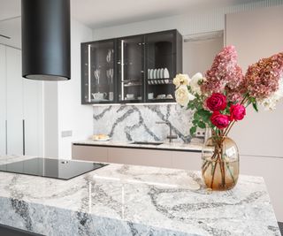 Kitchen in new luxury home with granite stone island with bouquet of flowers