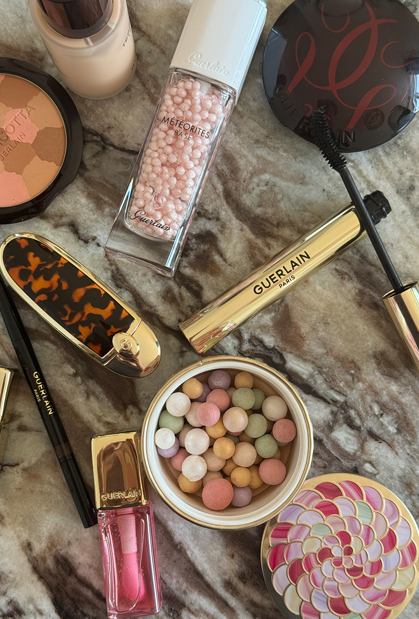 A flatlay picture of Guerlain makeup products on a marbled surface