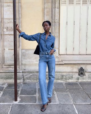 A French woman wearing a denim shirt with jeans.