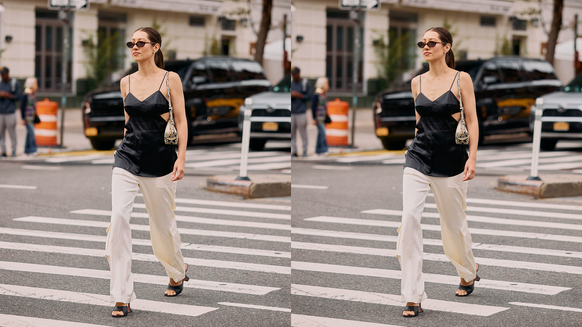 Woman wears black satin tank, white pants, and heeled sandals while walking on a cross walk.