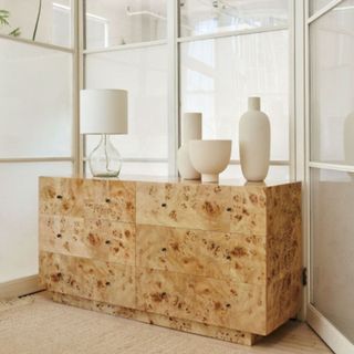 West Elm Burl Dresser, with trinkets on top, set in a mirrored space.