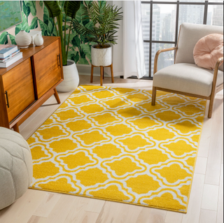 A yellow patterned rug in a living room.