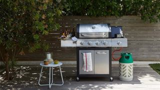 A stainless steel barbecue on a walled patio