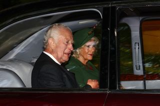 Queen Camilla and King Charles riding in a car in 2024