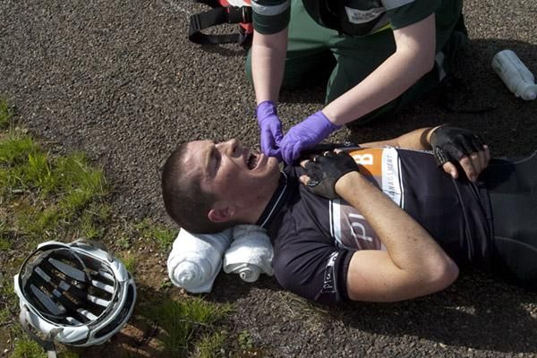 Sam Davis (Plan B Racing Team) from Western Australia feels the pain as a medical officer checks his collarbone after a crash on stage eleven.