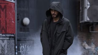 Jared Leto in black hoodie walking down alleyway in Morbius