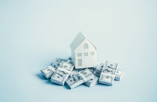 visualization of a model house on stacks of currencies