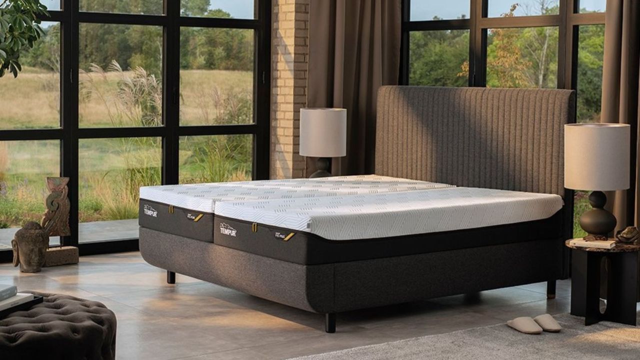 Tempur Pro Plus Smart Cool Mattress on a bed against floor-to-ceiling windows, looking out onto a garden.