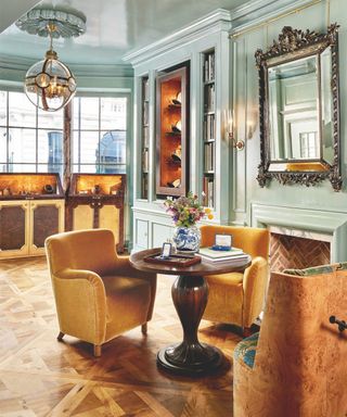 commercial space with wooden table and yellow velvet armchairs and mint green walls