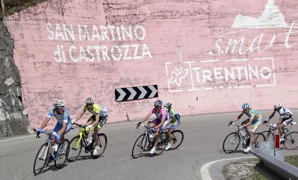 Riders reach San Martino di Castrozza on the ascent of the Passo Rolle.