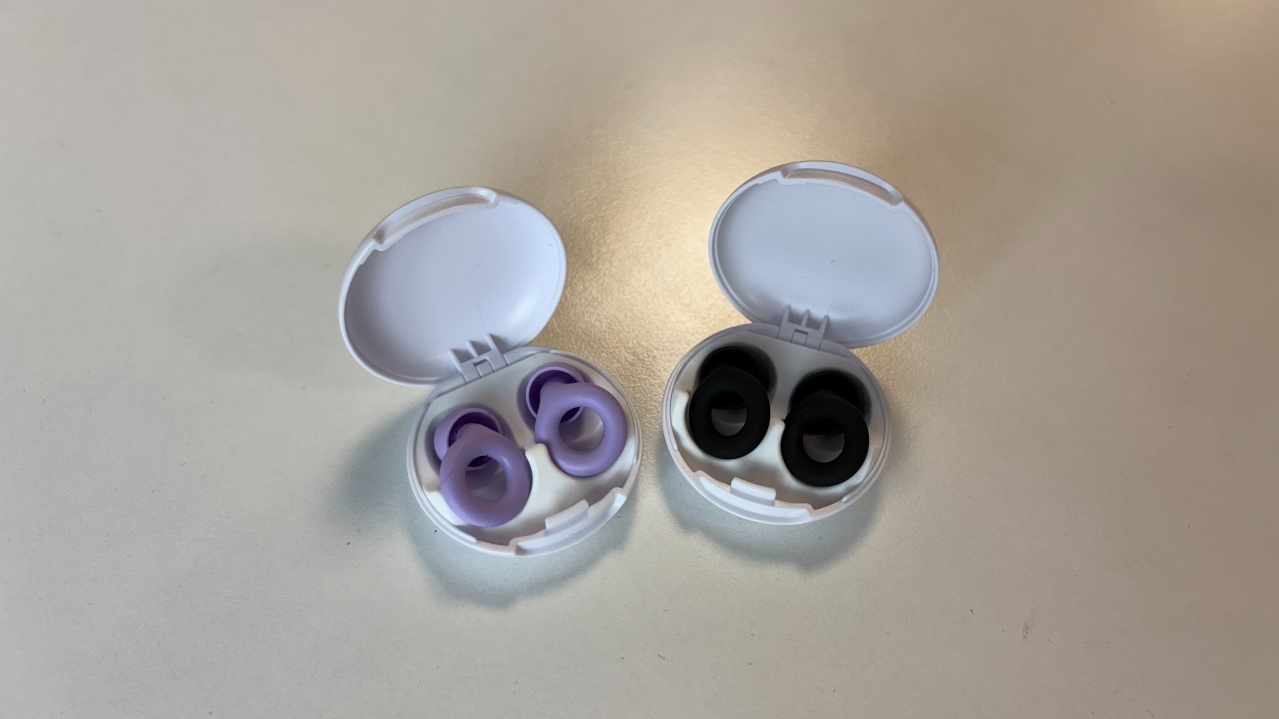 2 pairs of Loop Quiet 2 Earplugs, one in a black shade and the other in lilac.