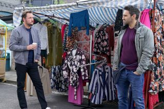 Martin and Kush talk in the market in EastEnders