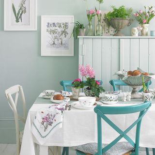 dining table with flowers and colorful chairs
