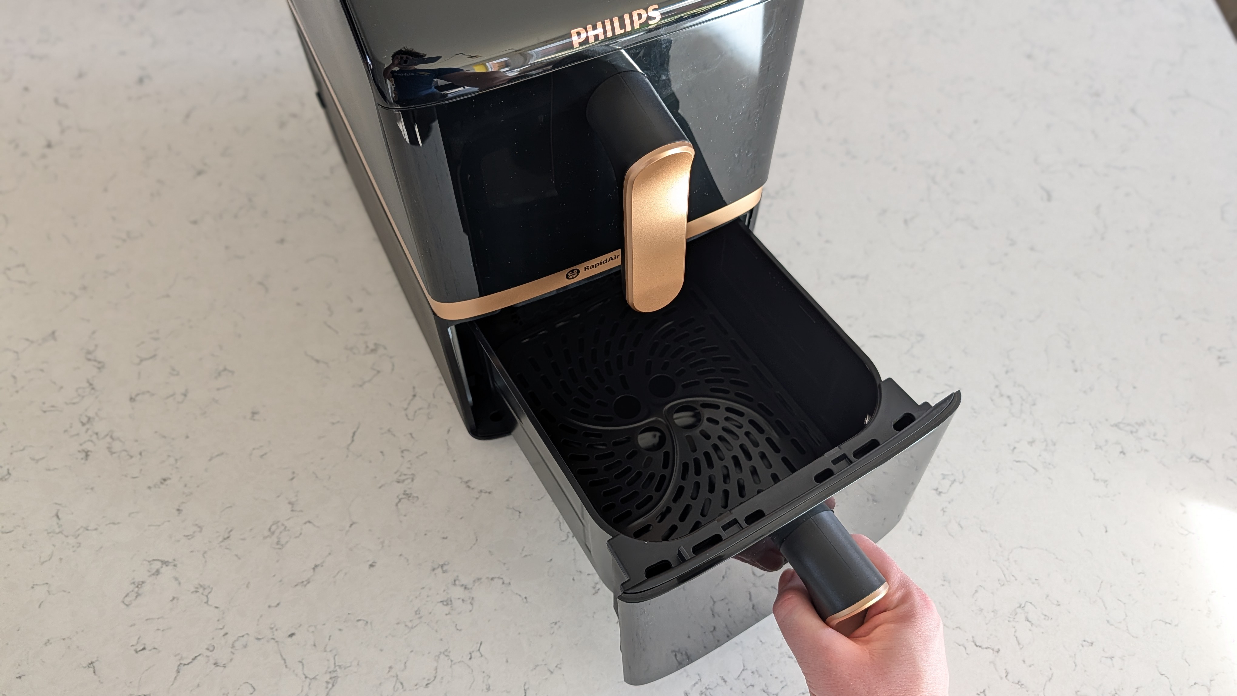 Philips 4000 Series Airfryer with person's hand opening bottom drawer