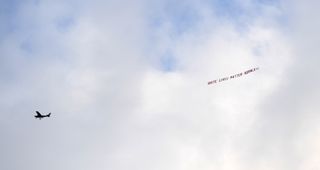 A plane flies the offending banner over the Etihad Stadium.
