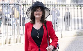 Vicki Michelle wearing a black hat and red blazer