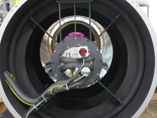 A view down the throat of the DFM telescope with the ATLAS camera mounted on the spider ring. The magenta area is the reflection off of the interference visual filter in front of the ATLAS detector and the primary mirror.