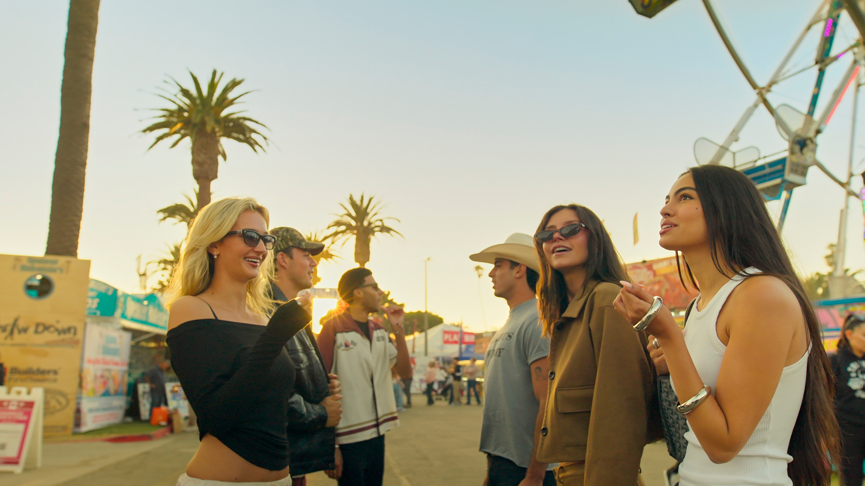 Suede, Preston, and Dylan hang out at a fair on a board walk in a still from netflix's calabasas confidential