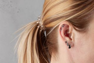 woman showing her right ear with multiple ear piercings