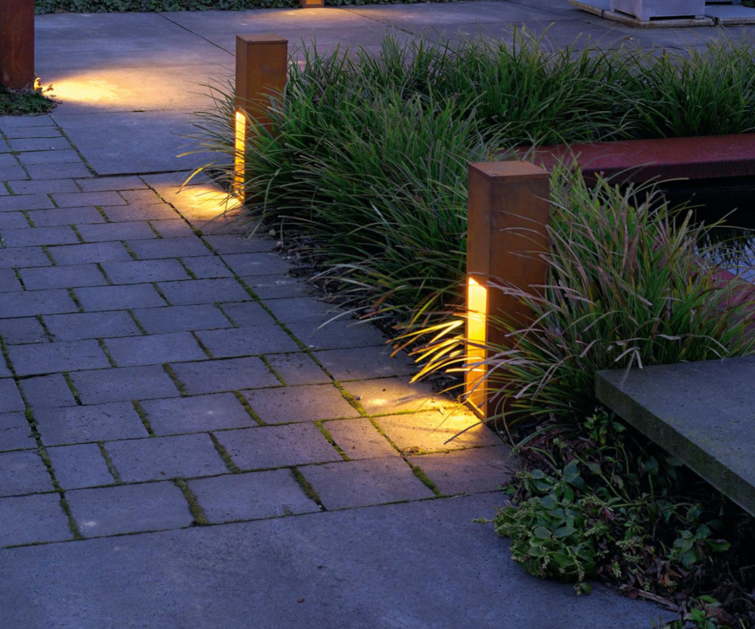 garden path lights set in border with ornamental grasses