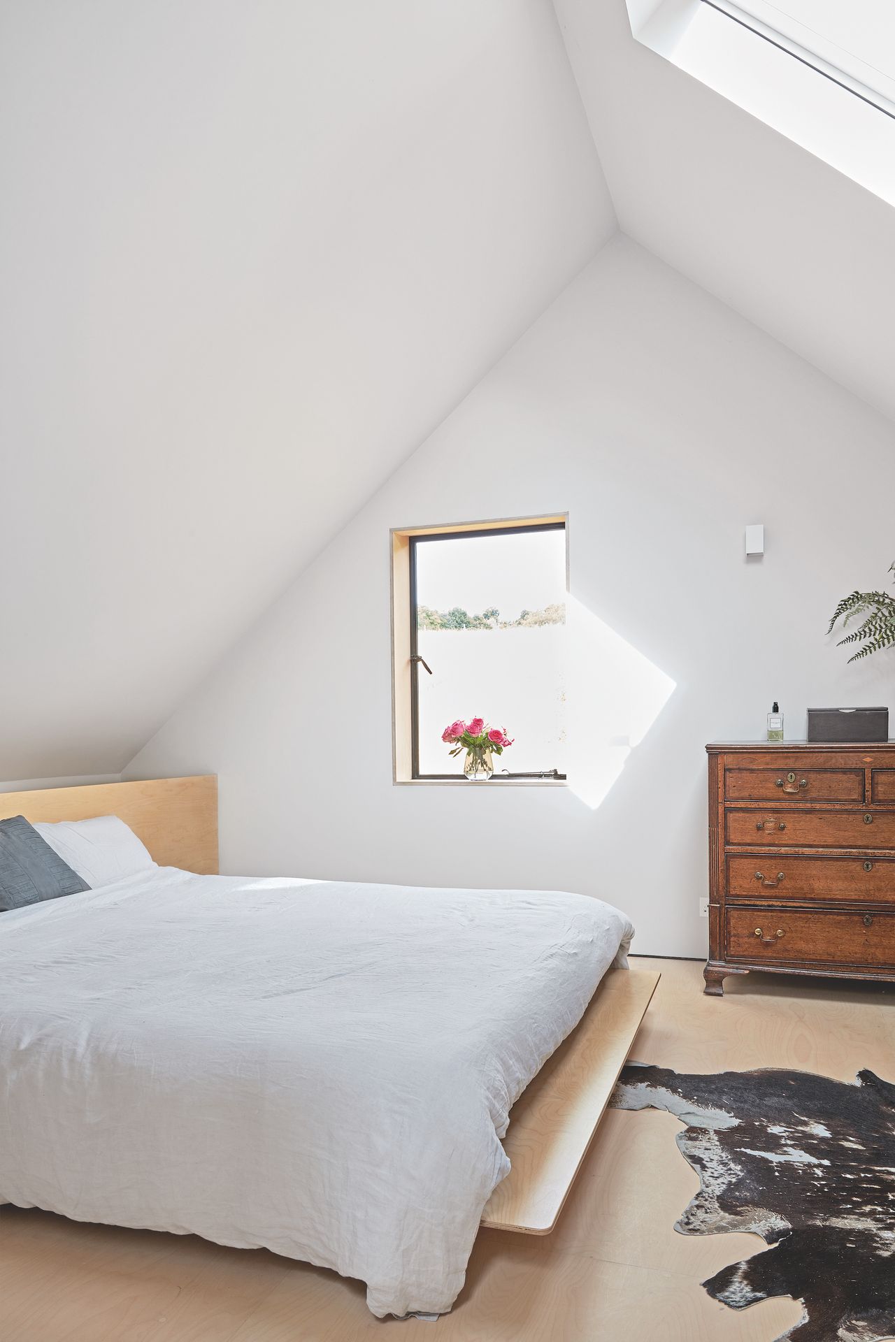 white bedroom with vaulted ceiling and picture window