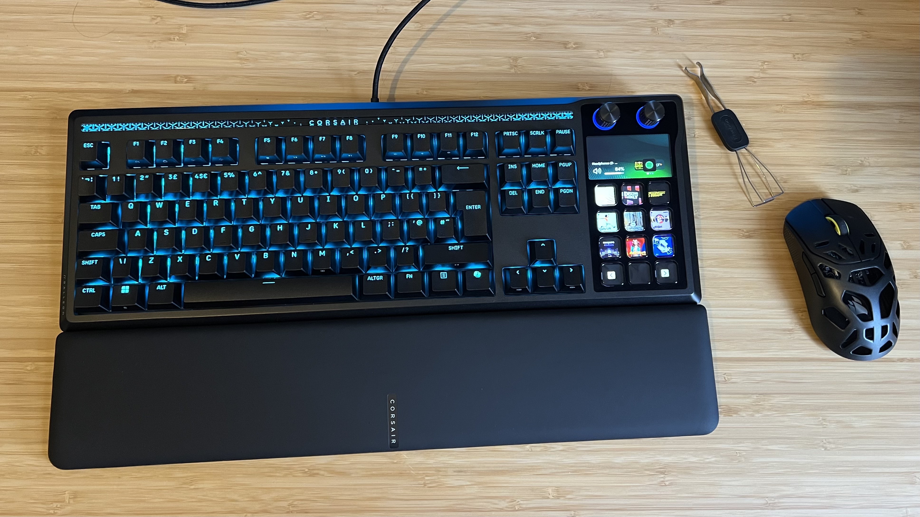 Corsair Galleon 100 SD gaming keyboard with wrist rest, mouse, and switch tool on a wooden desk
