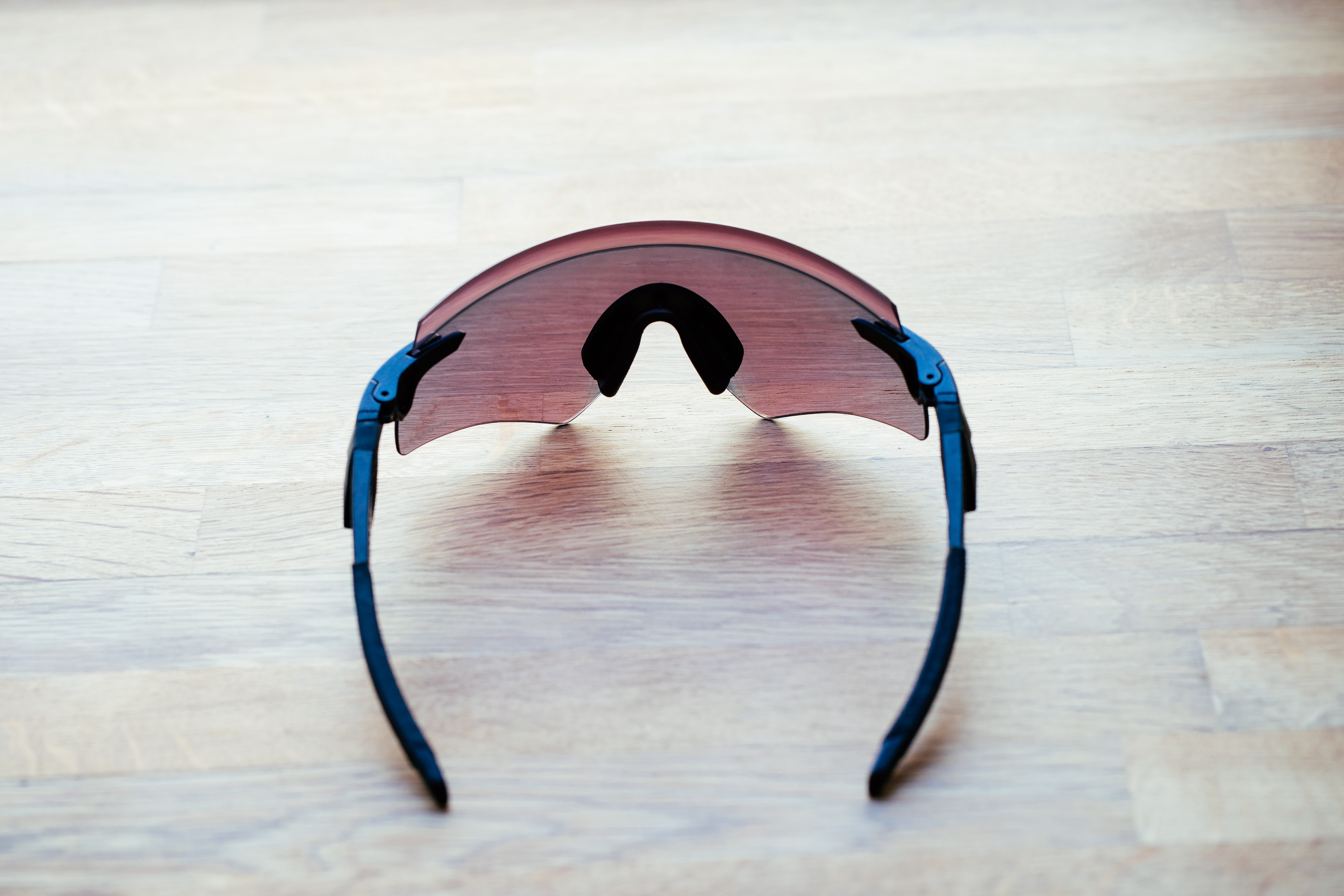 A set of frameless cycling glasses on a wooden surface