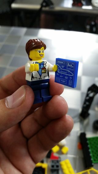 This mini-engineer holds a space shuttle blueprint in Lego's new Spaceport kit.