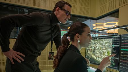 Michael Fassbender reviews data Marisa Abela is pointing out on her monitor in Black Bag.