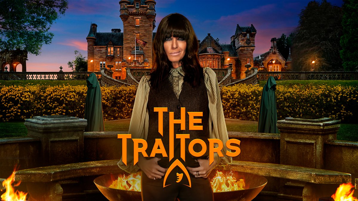 Host Claudia Winkleman poses in front of a Scottish castle and stone fire pits, with two mysterious green-cloaked figures in the background.