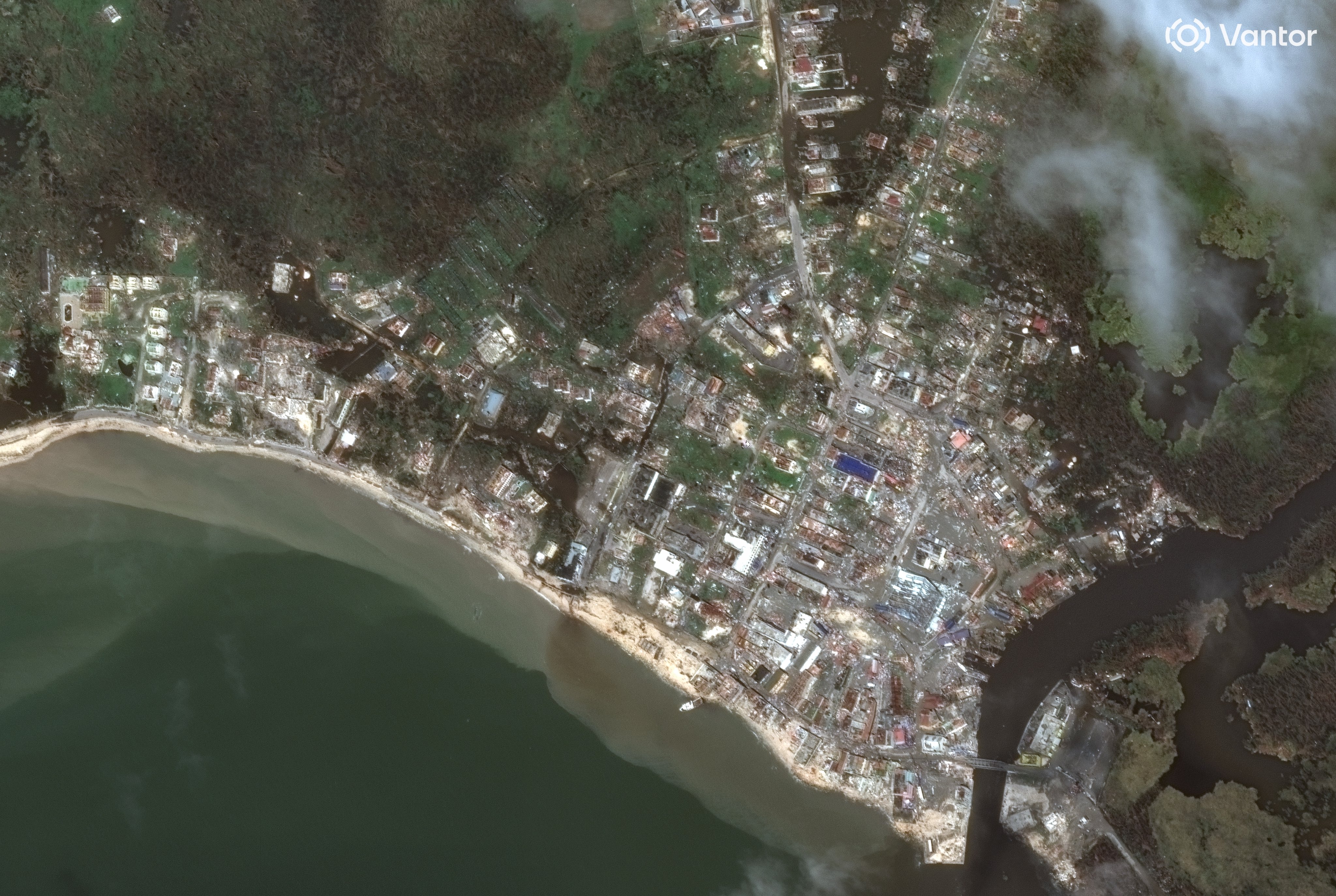 A series of satellite images from space showing the coastline of Jamaica with city blocks in ruins