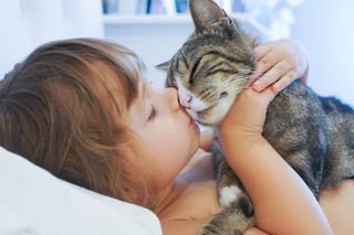 Child kisses a cat.