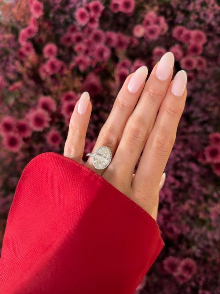 A close up picture of Elsa Hosk's engagement nails, featuring a sheer pink milky manicure with long almond nails