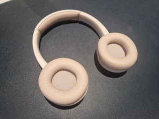 An off-white pair of BonoBeats Lite headphones sitting on a table