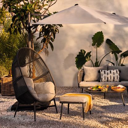 A rattan-effect egg chair in an outside living space