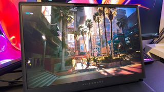 A close-up photo of the display of the Alienware 18 Area-51 gaming laptop, showing a screenshot of the Cyberpunk 2077 benchmark