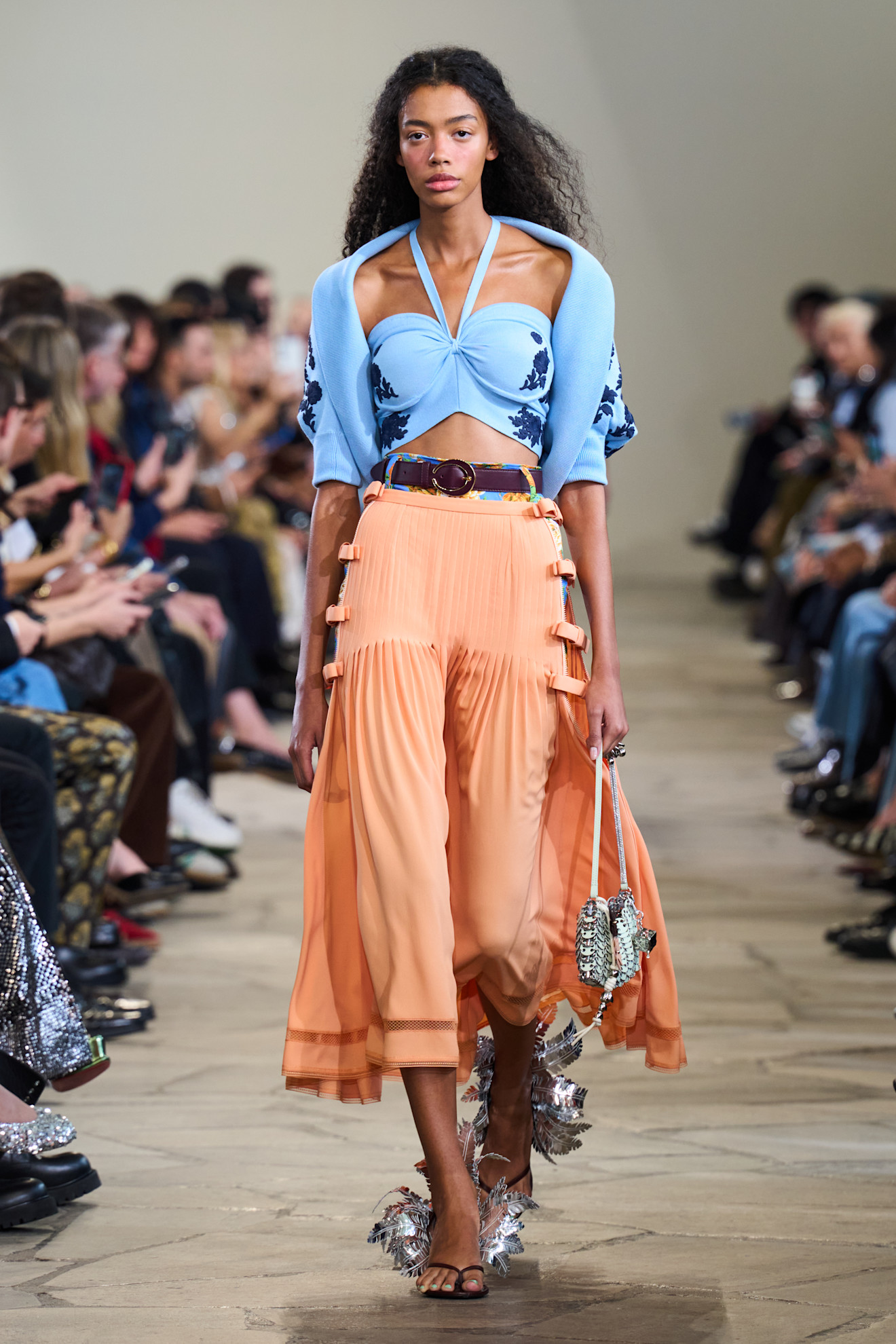 A model in a blue top and orange skirt on the Rabanne SS26 runway