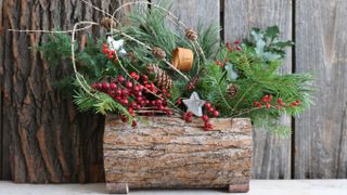 A wooden planter filled with Christmas decorations