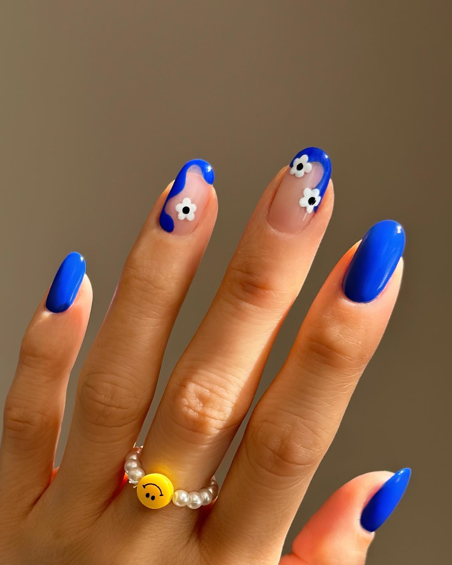Hand with long nails painted with cobalt blue nail polish