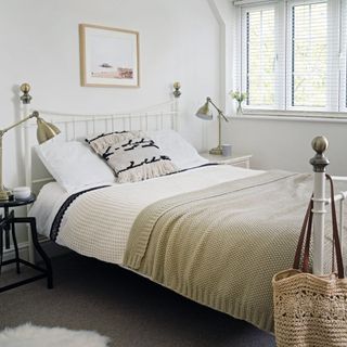 white duvet cover set in bedroom with beige cushion and blankets