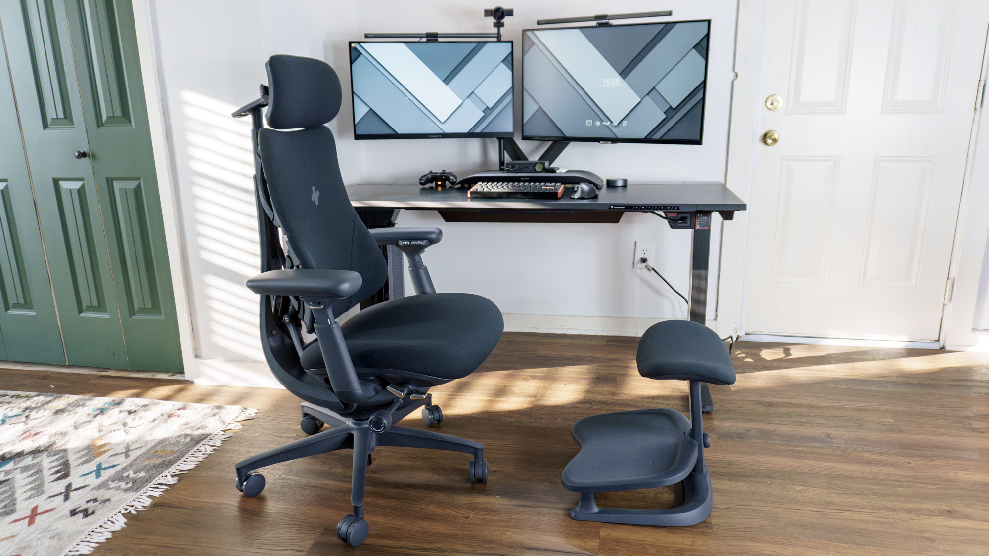 The LiberNovo Omni office chair with the LiberNovo StepSync footrest in front of a dual-monitor desk setup