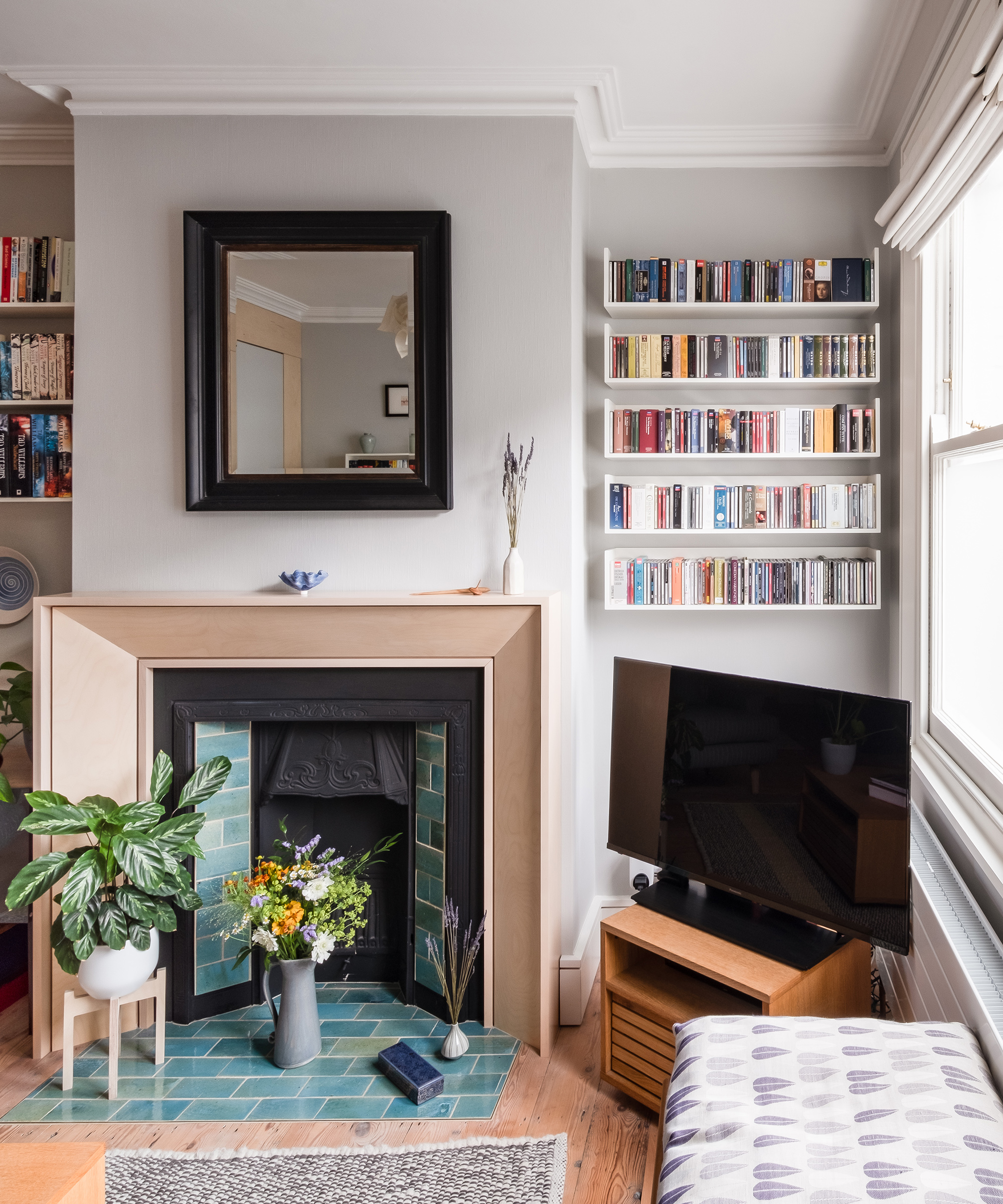 A small living room in a Victorian house and a fireplace with book shelves in an alcove