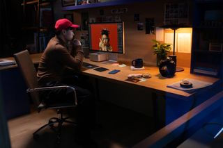Person in a red hat using Mac Studio with a monitor.