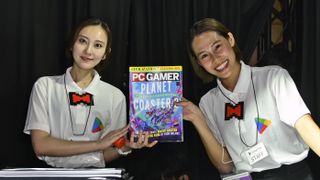 Tokyo Game Show 2024 reps holding PC Gamer magazine on the show floor