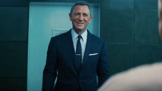 Daniel Craig smiles while laughing in an interrogation in No Time To Die.