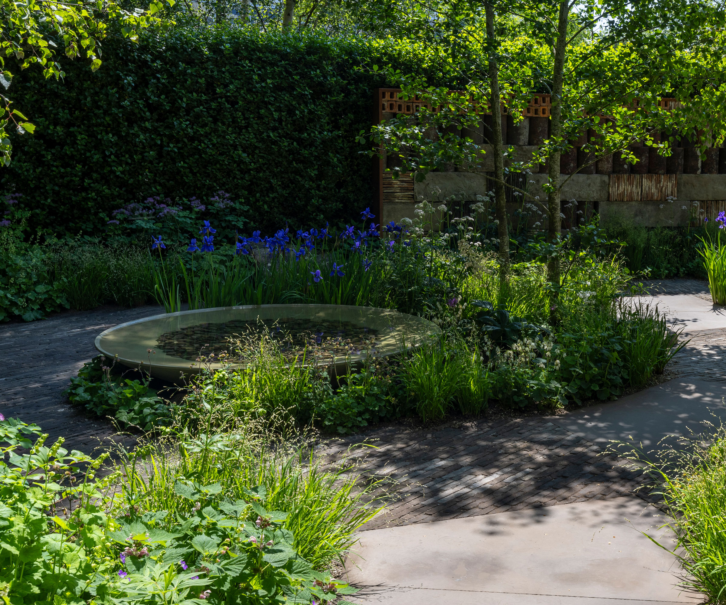 island bed design with water feature, trees and ornamental grasses
