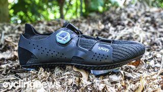UYN Man Naked Carbon shoes on a leafy backdrop