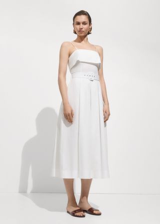 Model wears a white Mango Dress With a Belted Neckline