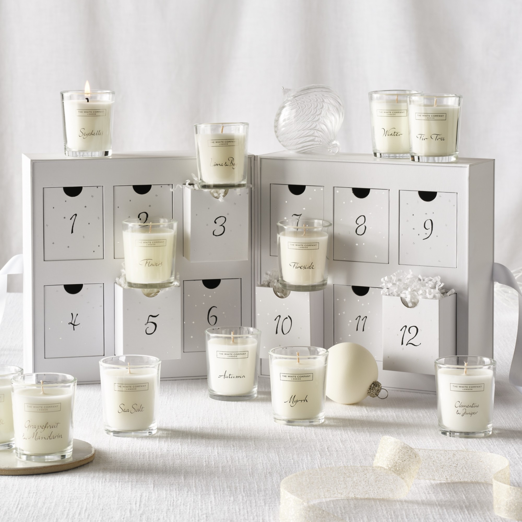 The White Company 12 Days Of Fragrance Advent Calendar open with the mini candles taken out and arranged
